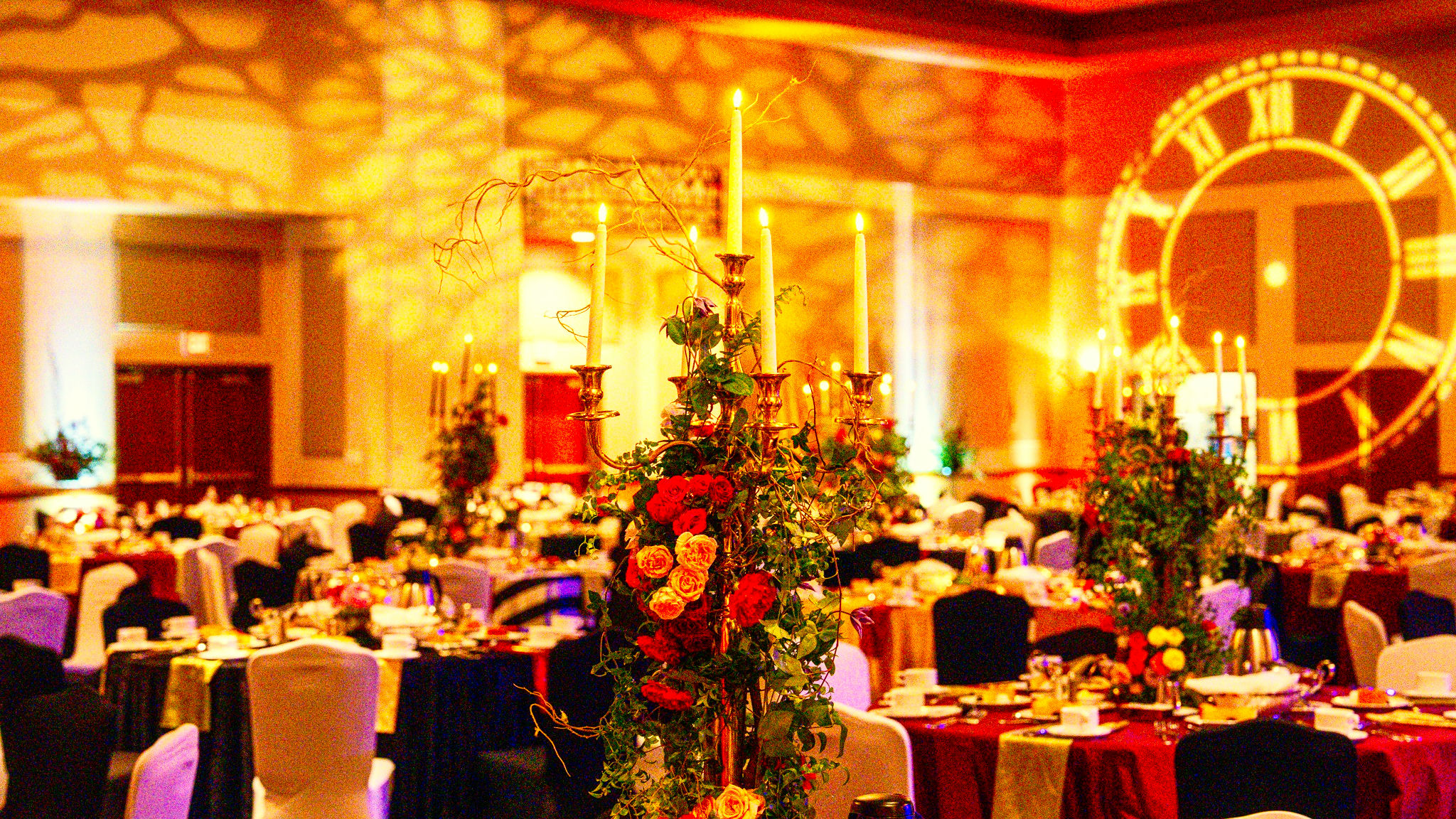 Immersive Wonderland set design with high-fashion couture detail, service hedge wall and 9-foot floral stilt walker environment